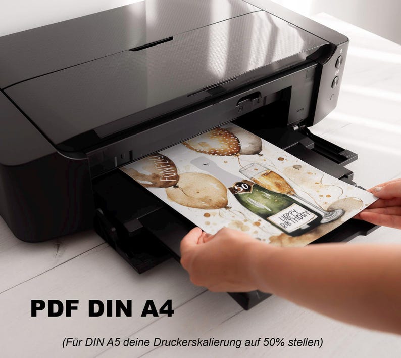 May include: A black printer with a white sheet of paper being inserted into the paper tray. The paper has a watercolor illustration of balloons, a bottle of champagne, and the text "Happy Birthday". The text "PDF DIN A4 (For DIN A5, set your printer scaling to 50%)" is printed below the image.