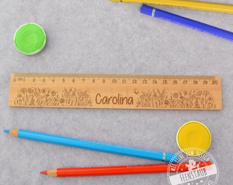 Könnte beinhalten: Ein Holzlineal mit einem floralen Design und dem eingravierten Namen "Carolina". Das Lineal ist 20 Zentimeter lang und hat Markierungen für jeden Zentimeter.