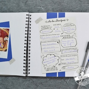May include: A white page with black text and drawings. The text includes "An das Brautpaar" and "Vertrauen". There are two silver glitter stickers on the page.