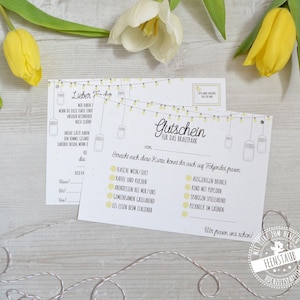 May include: Two white and yellow gift cards with text and illustrations, featuring a string of lights design. The cards are for a couple and include options like wine, brunch, and a picnic.