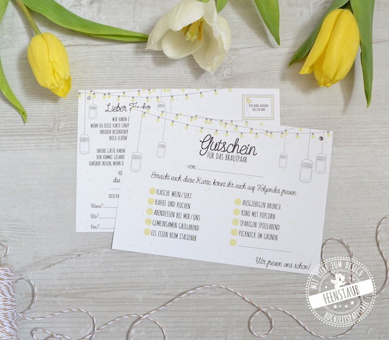 May include: Two white and yellow gift cards with text and illustrations, featuring a string of lights design. The cards are for a couple and include options like wine, brunch, and a picnic.