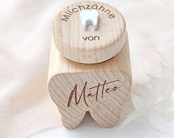 May include: Wooden tooth box with a white tooth cutout on the lid. The box is engraved with the text "Milchzähne von Matteo".