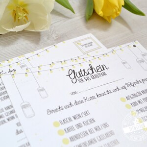 May include: White paper gift certificates with yellow accents and text. The certificates have a string of lights design and the words "Gutschein f&uuml;r das Brautpaar" in script. A yellow flower is in the background.