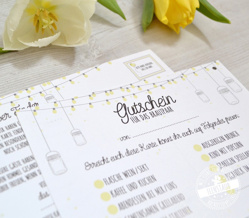 May include: White paper gift certificates with yellow accents and text. The certificates have a string of lights design and the words "Gutschein f&uuml;r das Brautpaar" in script. A yellow flower is in the background.