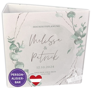 Könnte beinhalten: Ein weißer Hochzeitsplaner-Ordner mit einem Aquarell-Design aus Eukalyptusblättern und -zweigen. Der Ordner trägt den Text "Hochzeitsplanung" und die Namen "Melissa & Patrick" mit dem Datum "12.10.2024". Der Ordner trägt außerdem den Text "Ewig Dein - Ewig Mein - Ewig Uns" und einen handgefertigten Stempel mit der österreichischen Flagge.