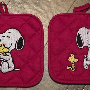 Op de afbeelding: Een witte keramische mok met een zwarte handgreep en de tekst "But First, Coffee" in een zwarte, vette letter. De mok staat op een wit oppervlak. De mok is ongeveer 10 cm hoog.