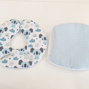 Könnte beinhalten: Ein Set aus zwei Babykissen. Eines ist ein hellblaues Waffel-Kissen. Das andere ist ein weißes Kissen mit einem blauen und grauen Koala-Druck. Der Koala-Druck zeigt Koalas, Wolken, Sterne und Regenbögen.