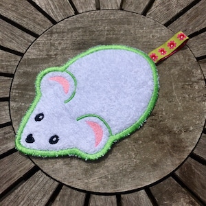 May include: White plush mouse with green embroidered outline and pink ears. The mouse has black eyes and a pink nose. It has a green and pink ribbon attached to the back.