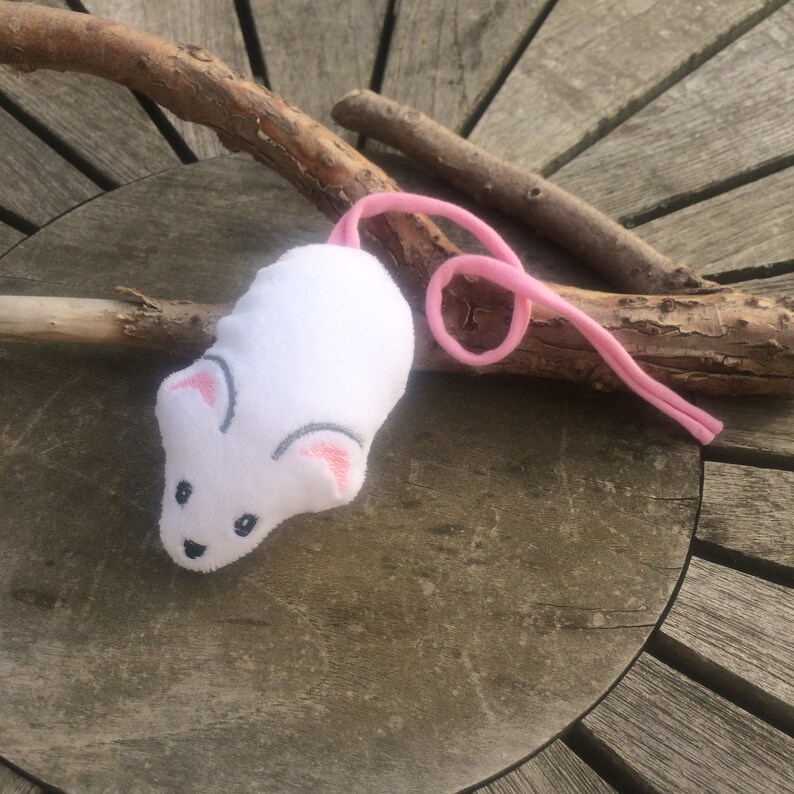 May include: White plush toy mouse with pink ears and a pink tail. The mouse has embroidered eyes and a nose.