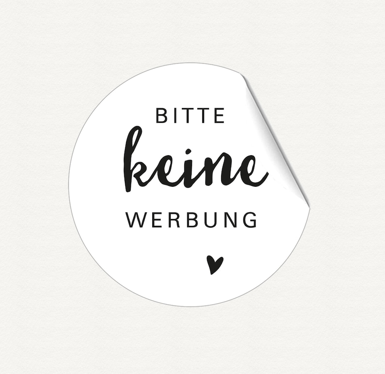 K&ouml;nnte beinhalten: Wei&szlig;er runder Aufkleber mit schwarzem Text "Bitte keine Werbung" und einem kleinen schwarzen Herz.