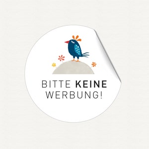 K&ouml;nnte beinhalten: Ein wei&szlig;er runder Aufkleber mit einem blauen Vogel mit orangefarbenen und gelben Akzenten, der auf einem grauen H&uuml;gel mit drei gelben und orangefarbenen Blumen sitzt. Der Text "Bitte keine Werbung!" ist in Schwarz gedruckt.