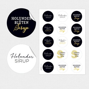 Könnte beinhalten: Ein Satz von 12 runden Aufklebern mit schwarzem und goldenem Text. Die Aufkleber sagen "Holunder Sirup" und "Holunder Blüten Sirup".