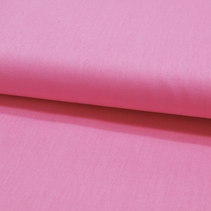 Könnte beinhalten: Nahaufnahme eines einfarbigen, rosa Stoffes mit subtiler Textur. Der Stoff ist gefaltet, wodurch ein Schatten entsteht, der dem Bild Tiefe verleiht. Die Farbe ist ein leuchtendes, mittleres Rosa.
