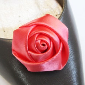 Pu&ograve; includere: Un fiocco di rosa in raso rosa brillante. La rosa &egrave; fatta di tessuto ed &egrave; un unico fiore.