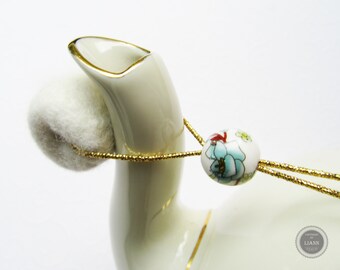 Tropfenfänger - China-Perle in weiß mit türkis Blüten und Ästen in rotbraun