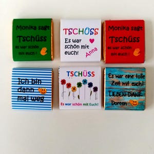 Könnte beinhalten: Sechs quadratische Schokoladentafeln in buntem Papier mit deutschem Text und Grafiken. Die Verpackungen zeigen grüne, weiße, rote, blau gestreifte und holzmaserierte Muster mit Aufschriften wie Monika sagt Tschüss, Anna und Ich bin dann mal weg.