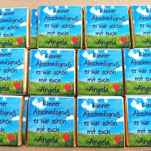 Könnte beinhalten: Eine Sammlung quadratischer Schokoladentafeln in Papierverpackung mit blauem Himmel, weißen Wolken und einer grünen Wiese. Der Text lautet: Kleiner Abschiedsgruß es war schön mit euch Angela, ergänzt durch ein kleines rotes Herz-Symbol.
