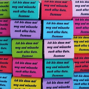 Könnte beinhalten: Eine Sammlung von 12 bunten Getränkedosenkühlern mit dem Text "Ich bin dann mal weg und wünsche euch alles Gute. Susanne" auf jedem.