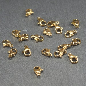 May include: A collection of gold-toned metal lobster claw clasps, commonly used for jewellery making.