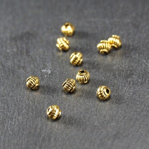 10 small beads 5 mm, grooved, barrel, antique gold, 10469