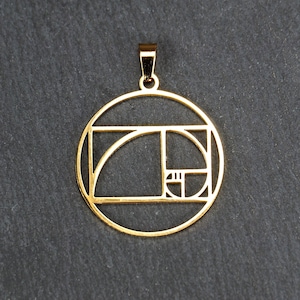 Op de afbeelding: Een gouden ketting met een hanger in de vorm van een cirkel met een geometrisch patroon geïnspireerd op de Fibonacci-reeks, ook wel bekend als de Gulden Snede.