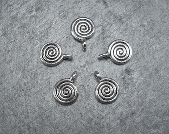 Puede incluir: Cinco abalorios de metal plateados con un diseño en espiral. Cada abalorio tiene un pequeño bucle para sujetarlo a un collar o pulsera.