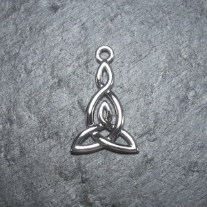Puede incluir: Encanto de colgante de nudo celta de plata con un diseño de nudo triple. El colgante tiene un bucle en la parte superior para sujetarlo a un collar o pulsera.