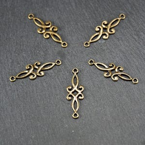 Puede incluir: Cinco piezas de conexi&oacute;n de metal dorado con dise&ntilde;os intrincados. Cada pieza tiene dos bucles para sujetar a otros componentes de joyer&iacute;a.