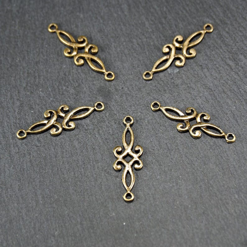 Puede incluir: Cinco piezas de conexi&oacute;n de metal dorado con dise&ntilde;os intrincados. Cada pieza tiene dos bucles para sujetar a otros componentes de joyer&iacute;a.