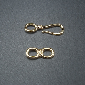 May include: Two gold-toned metal clasps. One clasp is a hook and loop design, the other is a double loop design.