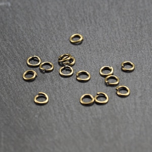 May include: A collection of 15 gold jump rings, ideal for jewellery making or crafting projects.