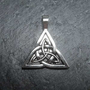 Puede incluir: Colgante de nudo celta de plata en forma de triángulo. El nudo es un símbolo tradicional de amor, amistad y unidad.