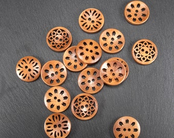 Puede incluir: Surtido de 13 botones de madera con intrincados diseños florales. Los botones son de color marrón y tienen un acabado de madera natural.