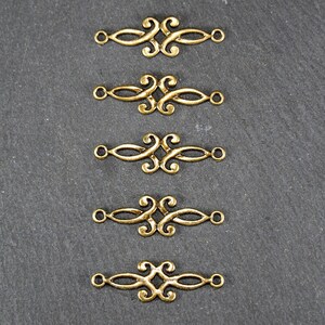 Puede incluir: Cinco conectores decorativos de metal dorado con un dise&ntilde;o de espiral. Cada conector tiene dos bucles en cada extremo.