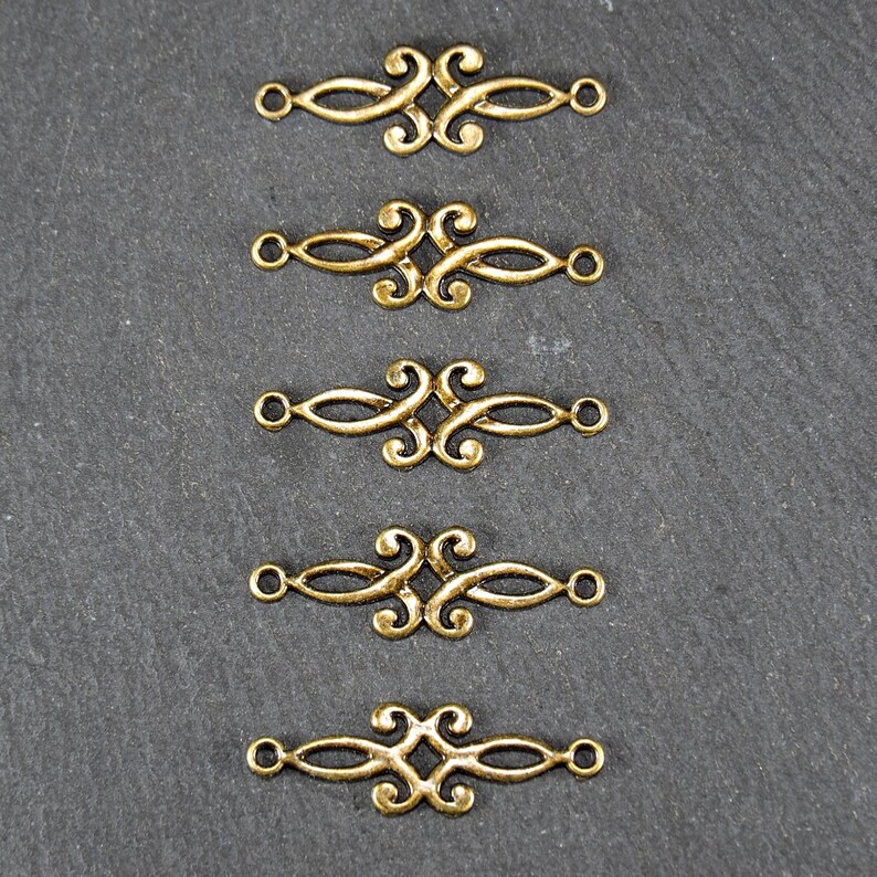 Puede incluir: Cinco conectores decorativos de metal dorado con un dise&ntilde;o de espiral. Cada conector tiene dos bucles en cada extremo.