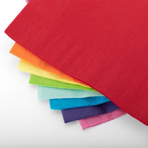 May include: A stack of colorful paper napkins in a rainbow pattern, starting with red and ending with pink.