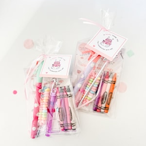 May include: Two clear cellophane bags filled with party favors. Each bag contains a pen, a bubble wand, and crayons. The bags are tied with pink ribbon and have a tag that reads "A Royal Thank You for Celebrating with Me!"