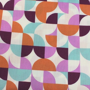 Könnte beinhalten: Ein weißer Stoff mit einem geometrischen Muster aus orangefarbenen, violetten, türkisfarbenen und burgunderroten Halbkreisen.