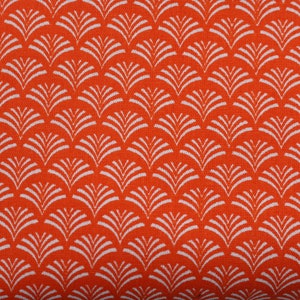 Op de afbeelding: Oranje stof met een wit, herhalend patroon van gestileerde bladeren.