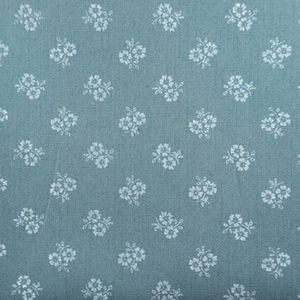 Puede incluir: Una tela de color verde azulado con un patrón repetitivo de pequeños grupos florales blancos de cuatro pétalos dispuestos en forma de cuadrícula. El material tiene una textura tejida visible y el estampado consta de diminutas flores delicadas.