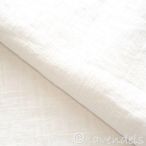 May include: White linen fabric with a smooth, even texture. The fabric is folded in half, showing the underside.