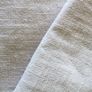 Peut inclure: Gros plan sur un tissu en lin blanc à armure texturée. Le tissu est plié en deux, montrant la texture de l'armure des deux côtés.