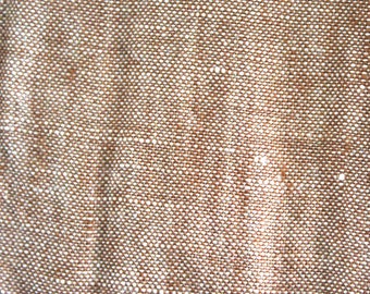 May include: Close-up of a brown fabric with a white speckled pattern. The fabric has a woven texture.