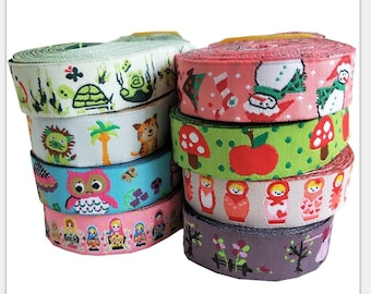 May include: A stack of decorative ribbon rolls with various colorful patterns. Designs include animals, holiday themes, and Russian nesting dolls. The ribbons are made of a woven material and are suitable for crafts and gift wrapping.