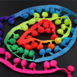 May include: Rainbow colored pom pom trim with a variety of colors including pink, green, blue, yellow, and red.