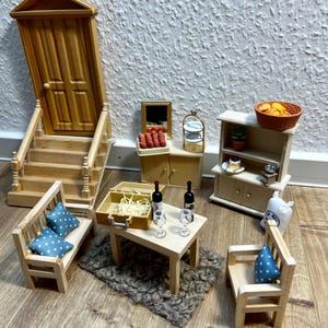 Könnte beinhalten: Miniatur-Möbelset aus Holz für ein Puppenhaus. Enthält eine Tür mit Treppe, eine Bank mit blauen Kissen, einen Tisch mit Weinflaschen und Gläsern, einen Schrank mit Lebensmitteln und einen Stuhl mit blauem Kissen.