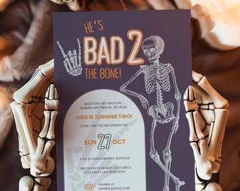 Peut inclure: Une invitation sur le thème d'Halloween avec une illustration de squelette et le texte "He's Bad 2 The Bone!". L'invitation concerne un deuxième anniversaire avec la date, l'heure et le lieu. L'invitation est tenue par une paire de mains de squelette.