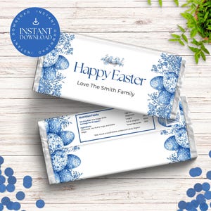 May include: A white chocolate bar wrapper with a blue and white floral design. The wrapper features a blue and white egg pattern and the text "Happy Easter Love The Smith Family".