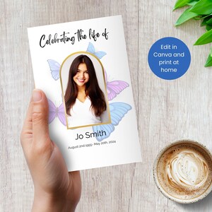 Op de afbeelding: Een witte kaart met een gouden lijst en een foto van een vrouw. De kaart heeft een vlinderontwerp en de tekst "Celebrating the life of Jo Smith August 2nd 1955- May 20th, 2024".