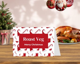 May include: A Christmas card with a red and white pattern featuring candy canes and Santa hats. The card reads "Roast Veg" and "Merry Christmas" in white text on a red background. A roasted turkey and Christmas ornaments are in the background.